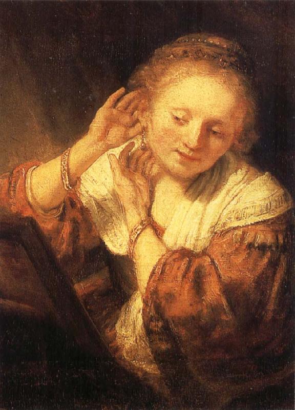REMBRANDT Harmenszoon van Rijn Young Woman Trying on Earrings oil painting image